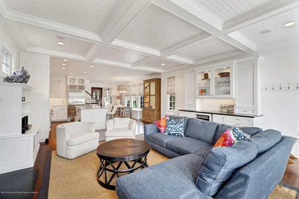 a living room with furniture and a dining table with kitchen view
