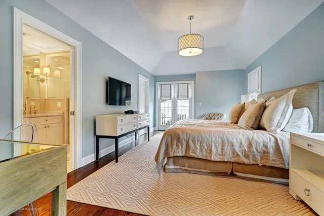 a spacious bedroom with a bed and a chandelier