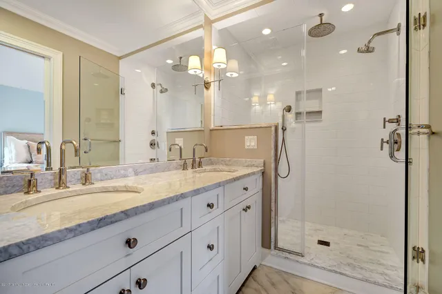 a bathroom with a granite countertop sink mirror and shower