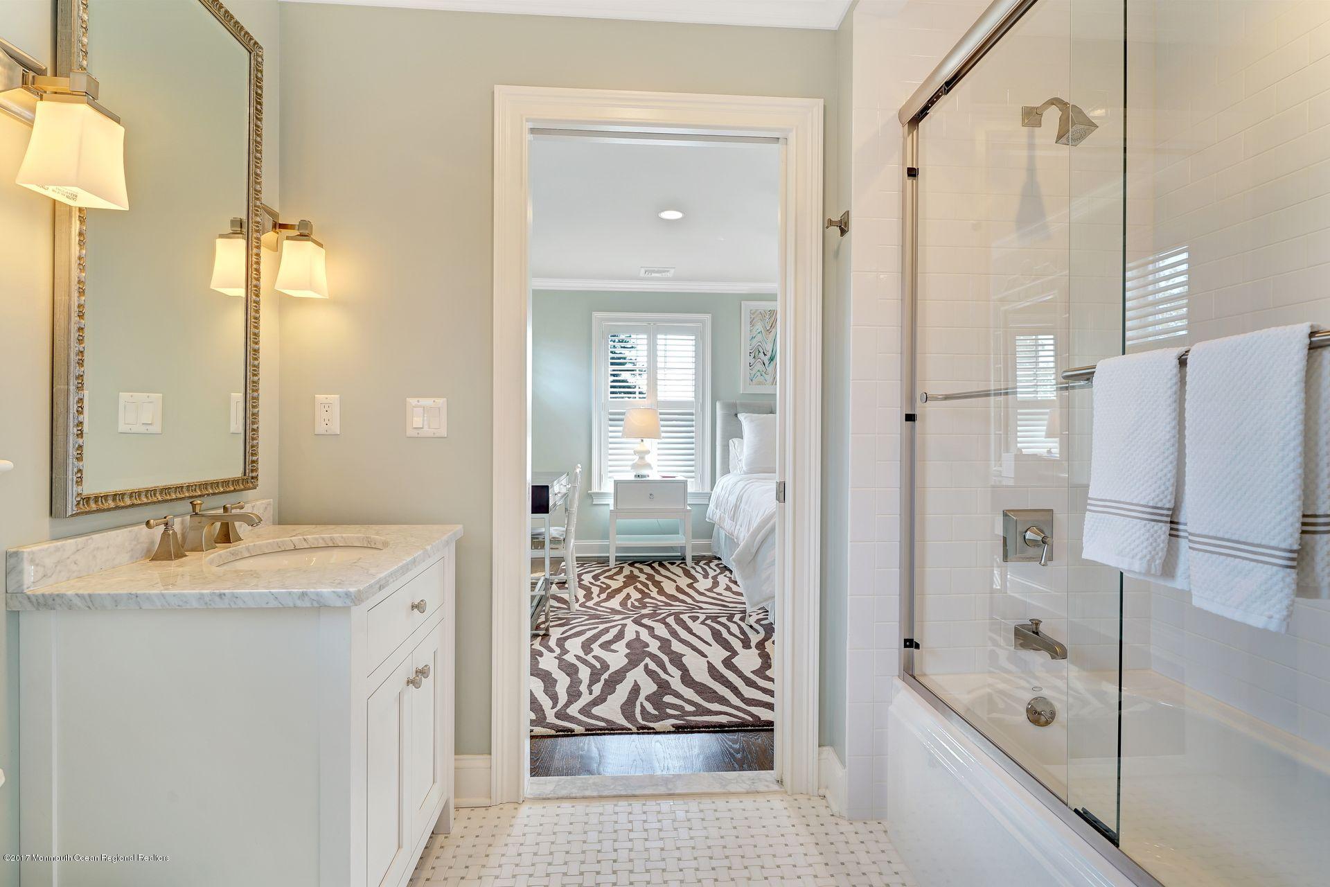 401 Monmouth Avenue Spring Lake, NJ 07762 - Photo 20 of 24 a bathroom with a granite countertop sink mirror bathtub and shower