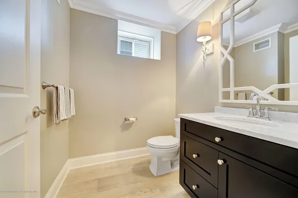 a bathroom with a granite countertop sink toilet a mirror and shower