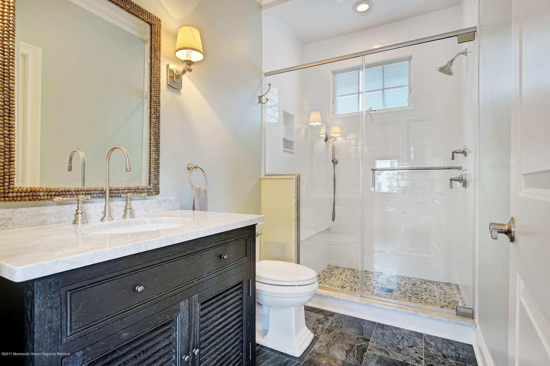 401 Monmouth Avenue Spring Lake, NJ 07762 - Photo 9 of 24 a bathroom with a granite countertop sink toilet a mirror and shower