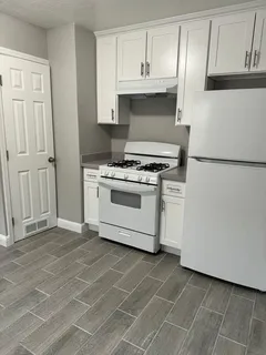 a stove top oven sitting inside of a kitchen