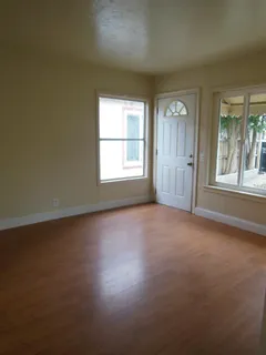 a view of empty room with wooden floor