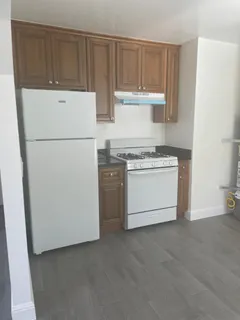 a kitchen with a stove top oven and white cabinets