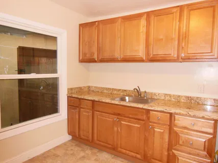 a view of a kitchen with wooden floor and cabinets