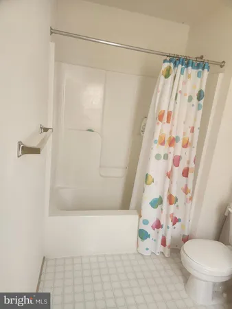 a bathroom with a shower curtain and a toilet