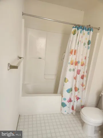 a bathroom with a shower curtain and a toilet
