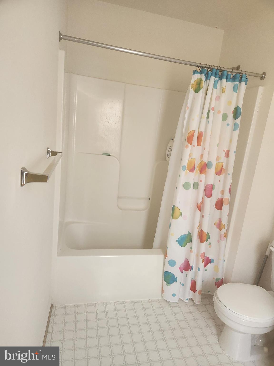5086 Stapleton Terrace Frederick, MD 21703 - Photo 12 of 24 a bathroom with a shower curtain and a toilet