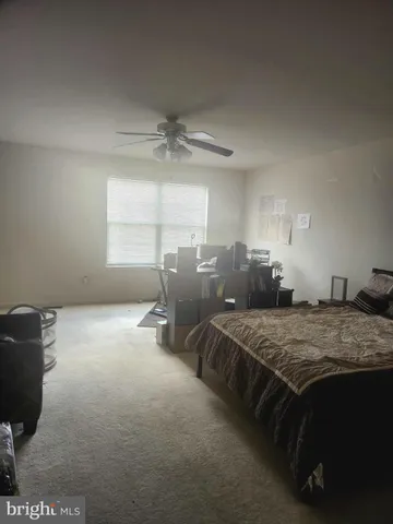 a bed sitting in a spacious bedroom next to a window
