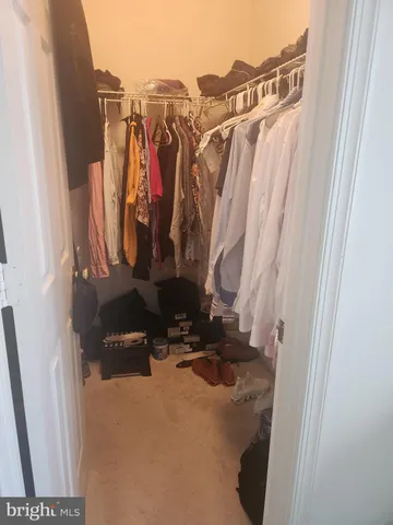 a view of walk in closet with clothes
