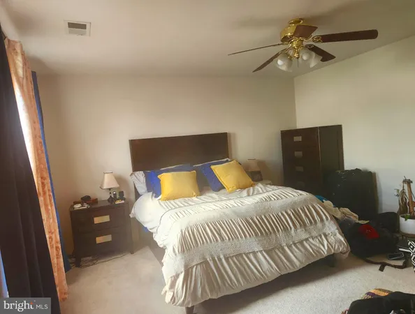 a bedroom with a bed and a ceiling fan