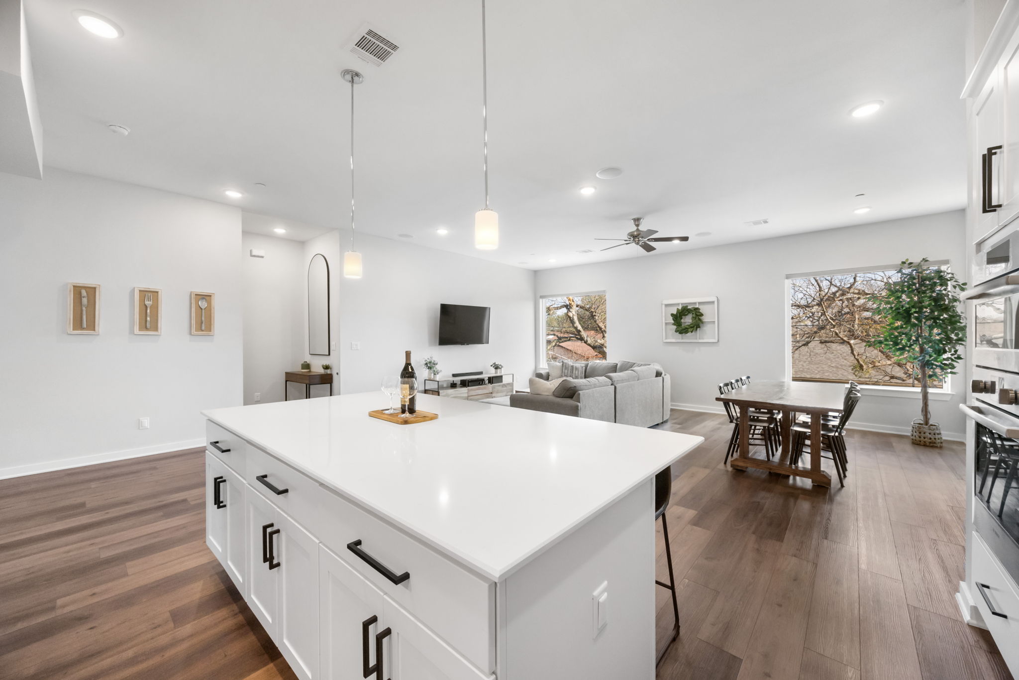 1417 Kramer Lane, Unit 14 Austin, TX 78758 - Photo 32 of 33 Kitchen with white cabinets, hanging light fixtures, open floor plan, dark wood-type flooring, and a center island