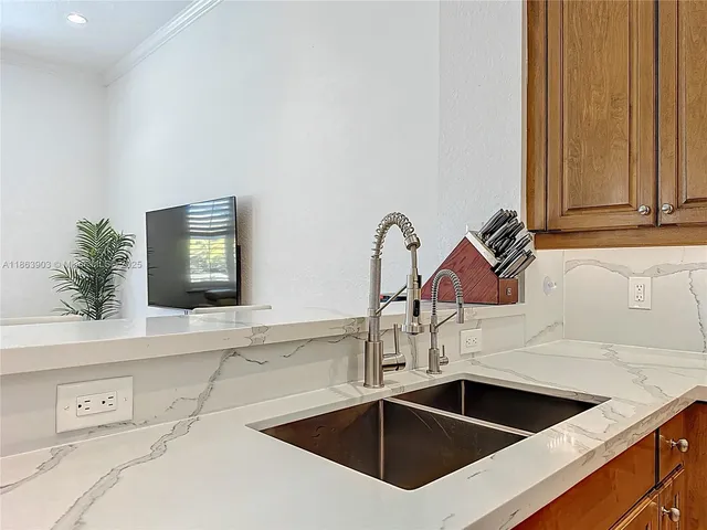 a kitchen with granite countertop a refrigerator stove top oven and sink