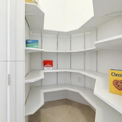 a living room with chairs and kitchen view with wooden floor