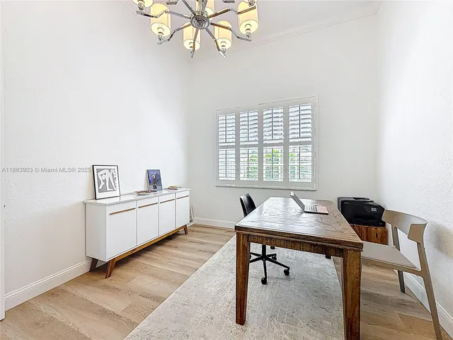 a view of a hallway with wooden floor and a bathroom