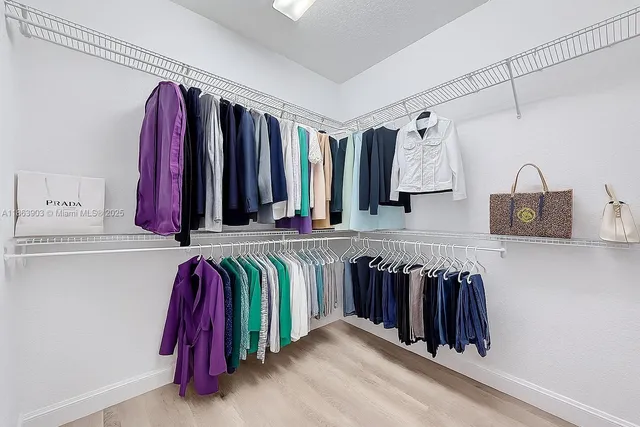 a view of walk in closet with clothes