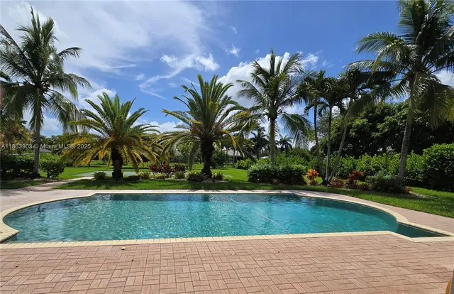 a group of people sitting in a yard with swimming pool