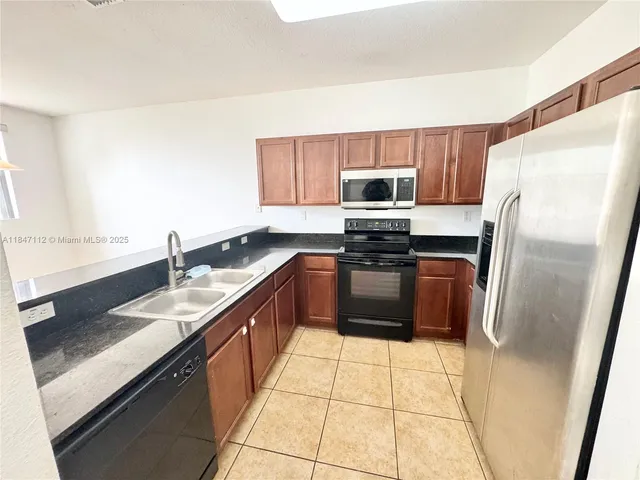 a kitchen with stainless steel appliances a refrigerator sink stove microwave and cabinets