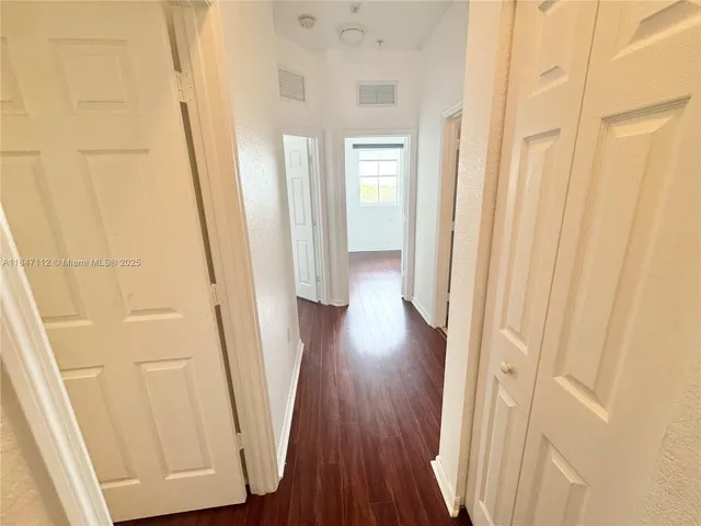 a view of a hallway with wooden floor