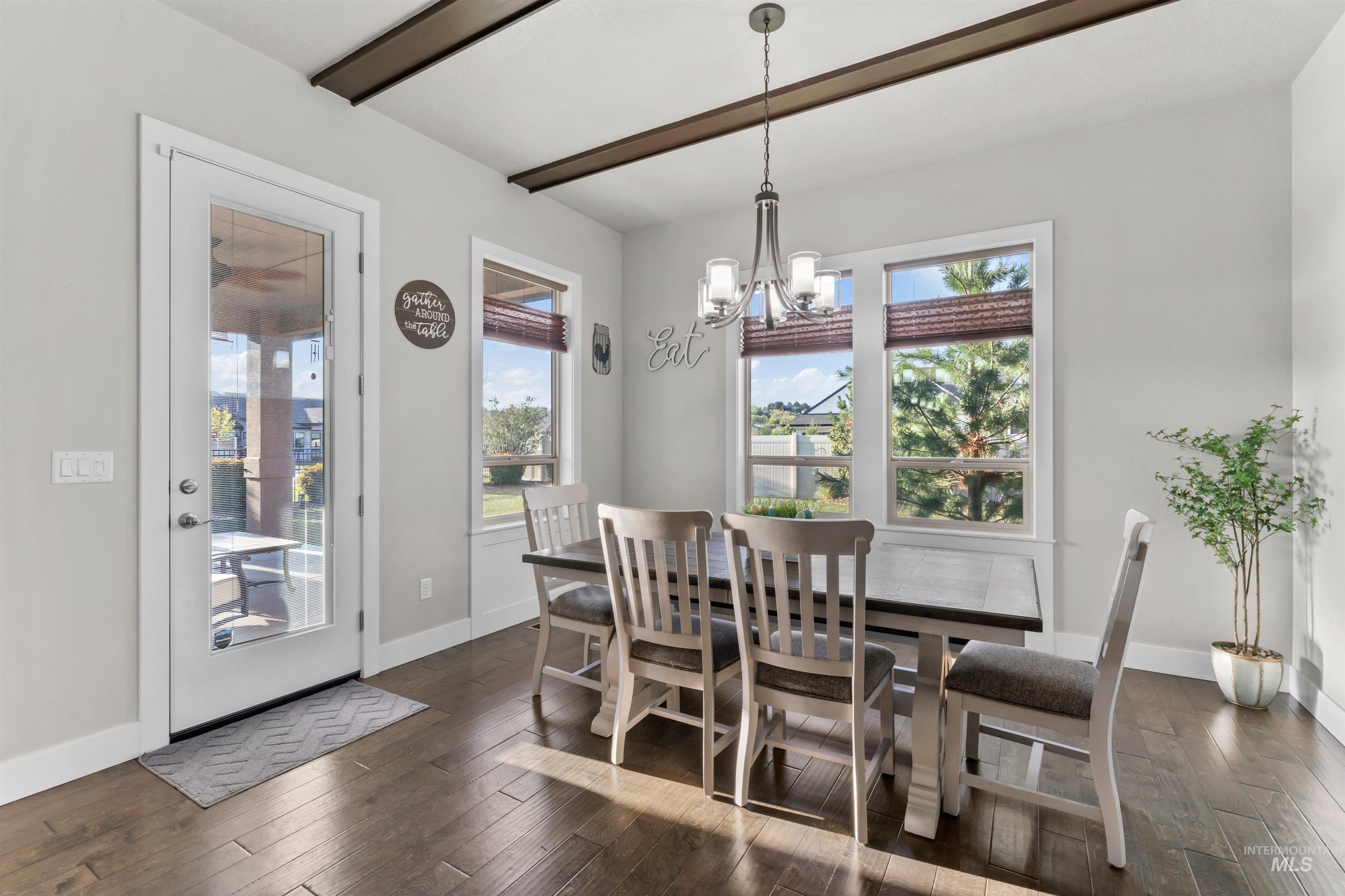 12356 West Rice Road Star, ID 83669 - Photo 14 of 49 Dining space featuring a chandelier, dark wood-style floors, healthy amount of natural light, and beam ceiling
