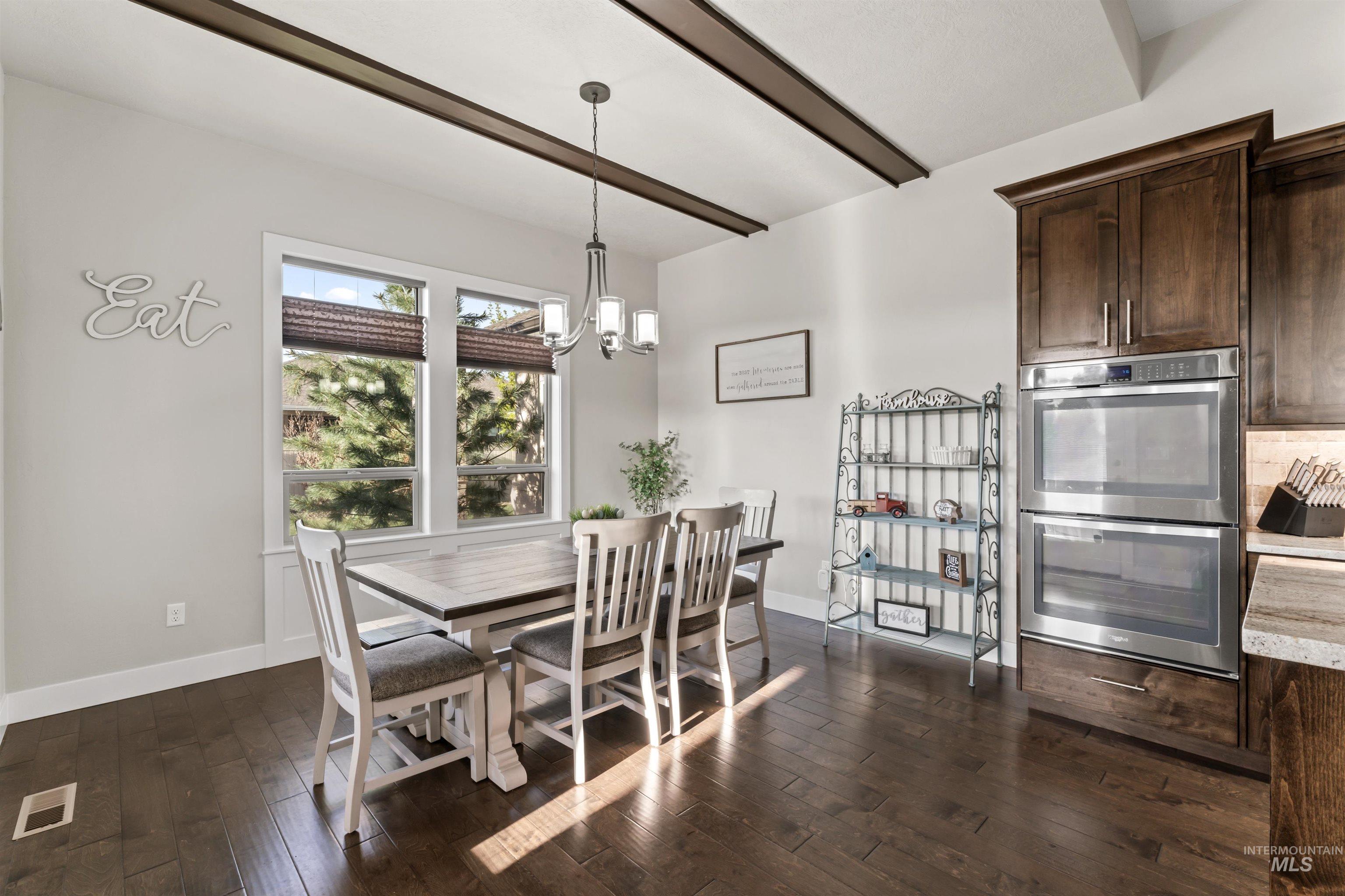 12356 West Rice Road Star, ID 83669 - Photo 15 of 49 Dining area with dark wood-style floors, a chandelier, and beam ceiling