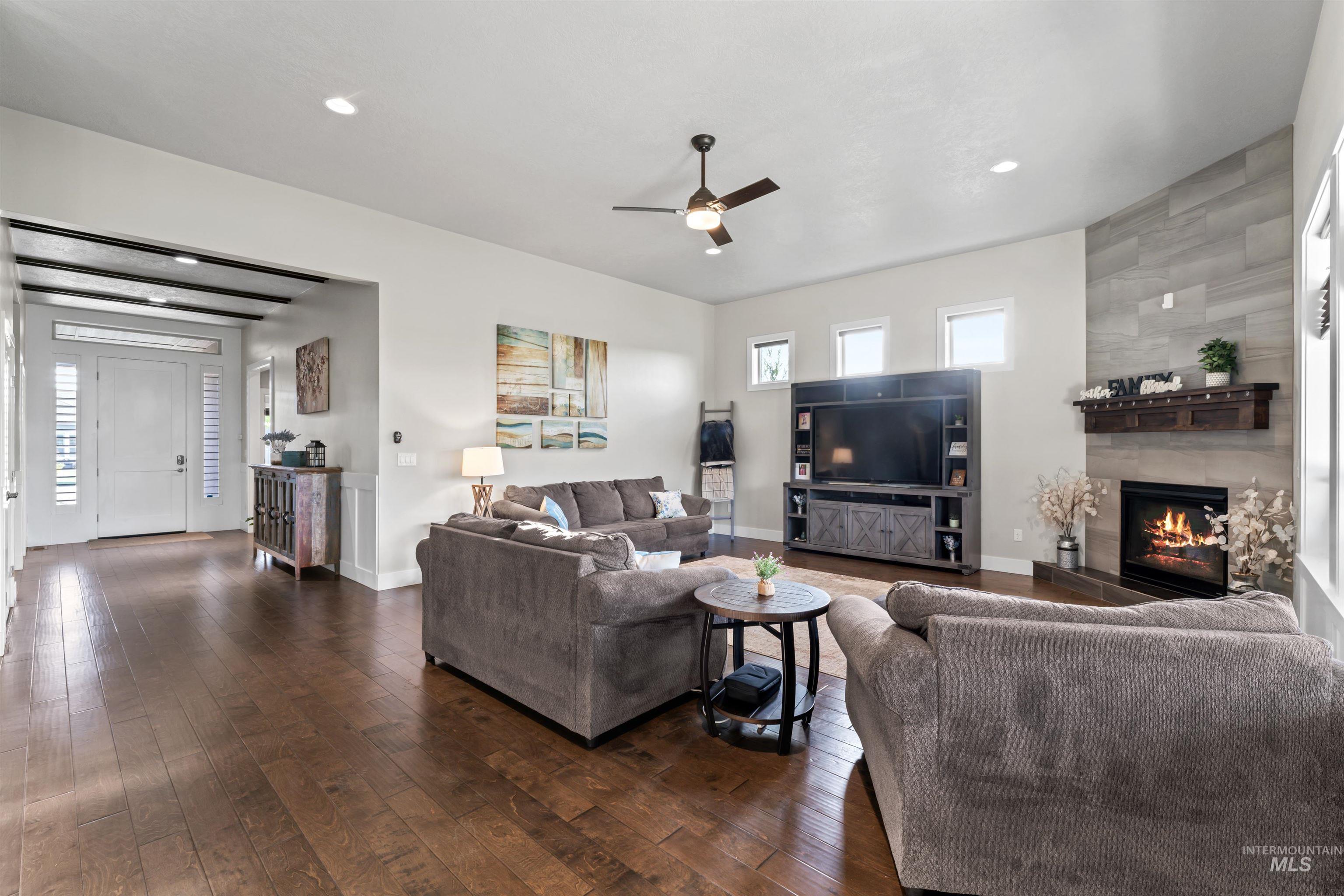 12356 West Rice Road Star, ID 83669 - Photo 16 of 49 Living room featuring dark wood-style flooring, ceiling fan, a fireplace, and recessed lighting