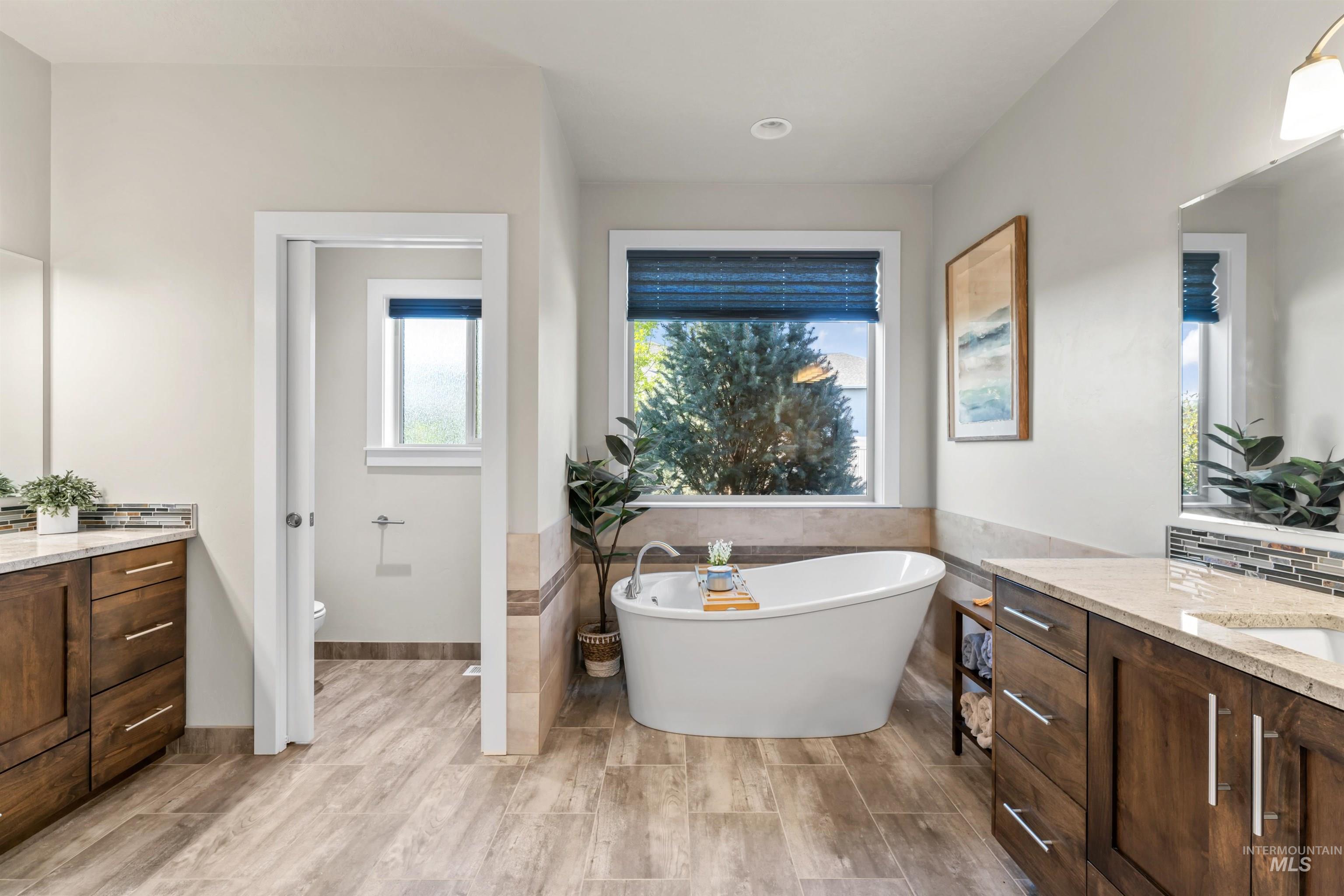 12356 West Rice Road Star, ID 83669 - Photo 21 of 49 Full bathroom featuring vanity, a freestanding tub, tile walls, and light wood-type flooring