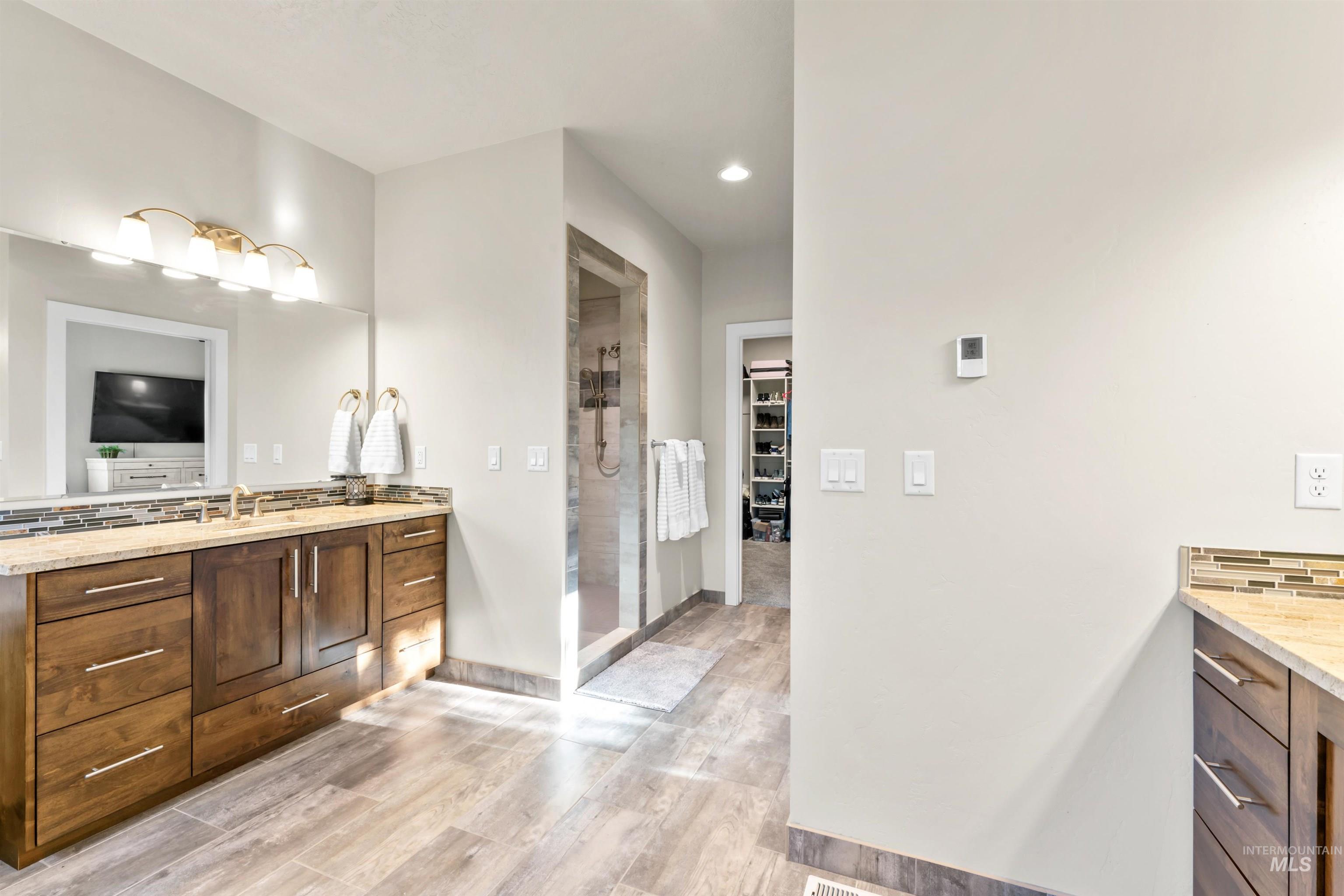 12356 West Rice Road Star, ID 83669 - Photo 24 of 49 Bathroom featuring vanity, a walk in closet, light wood-style flooring, a stall shower, and recessed lighting