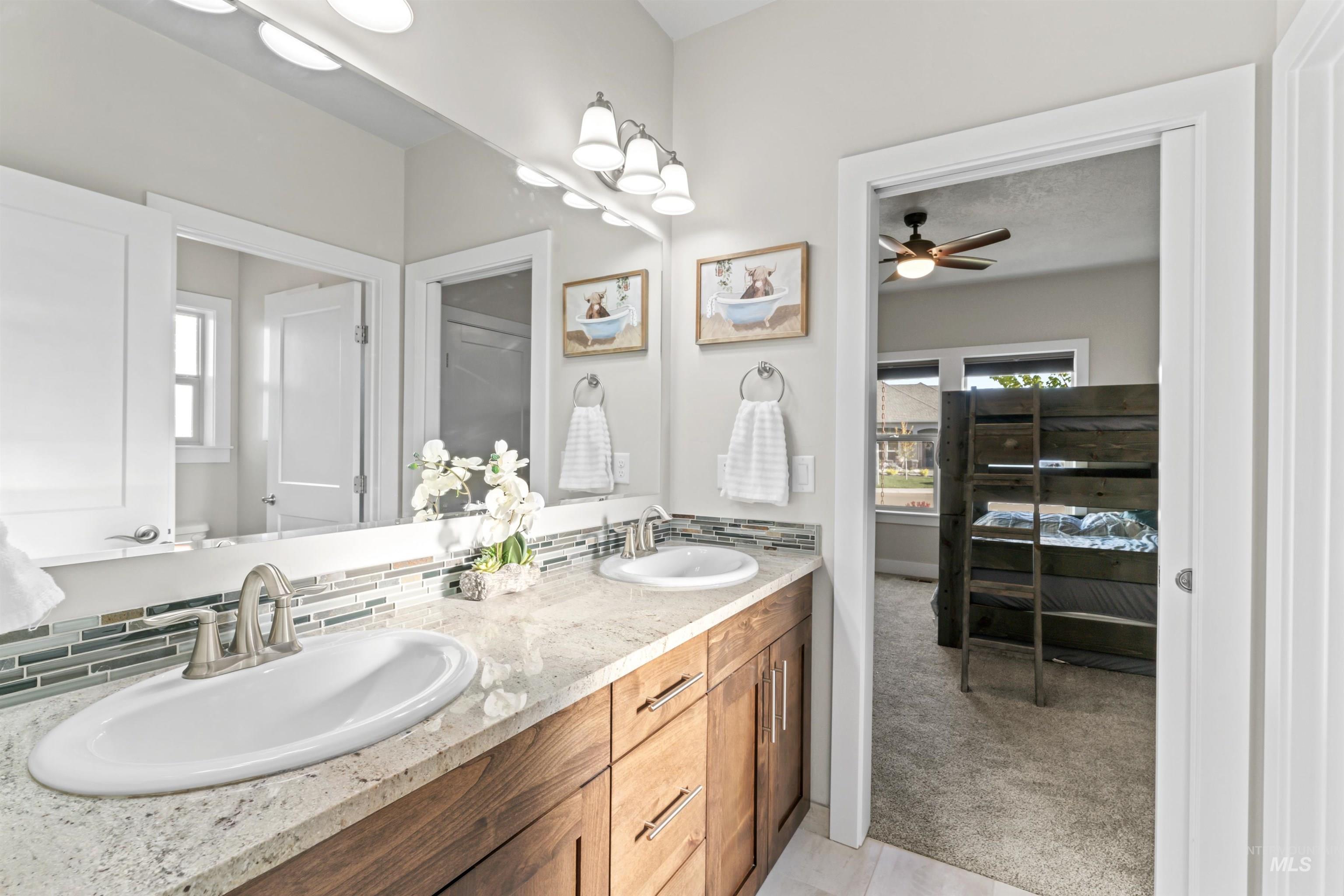 12356 West Rice Road Star, ID 83669 - Photo 29 of 49 Bathroom with light colored carpet, double vanity, ceiling fan, and light tile patterned floors