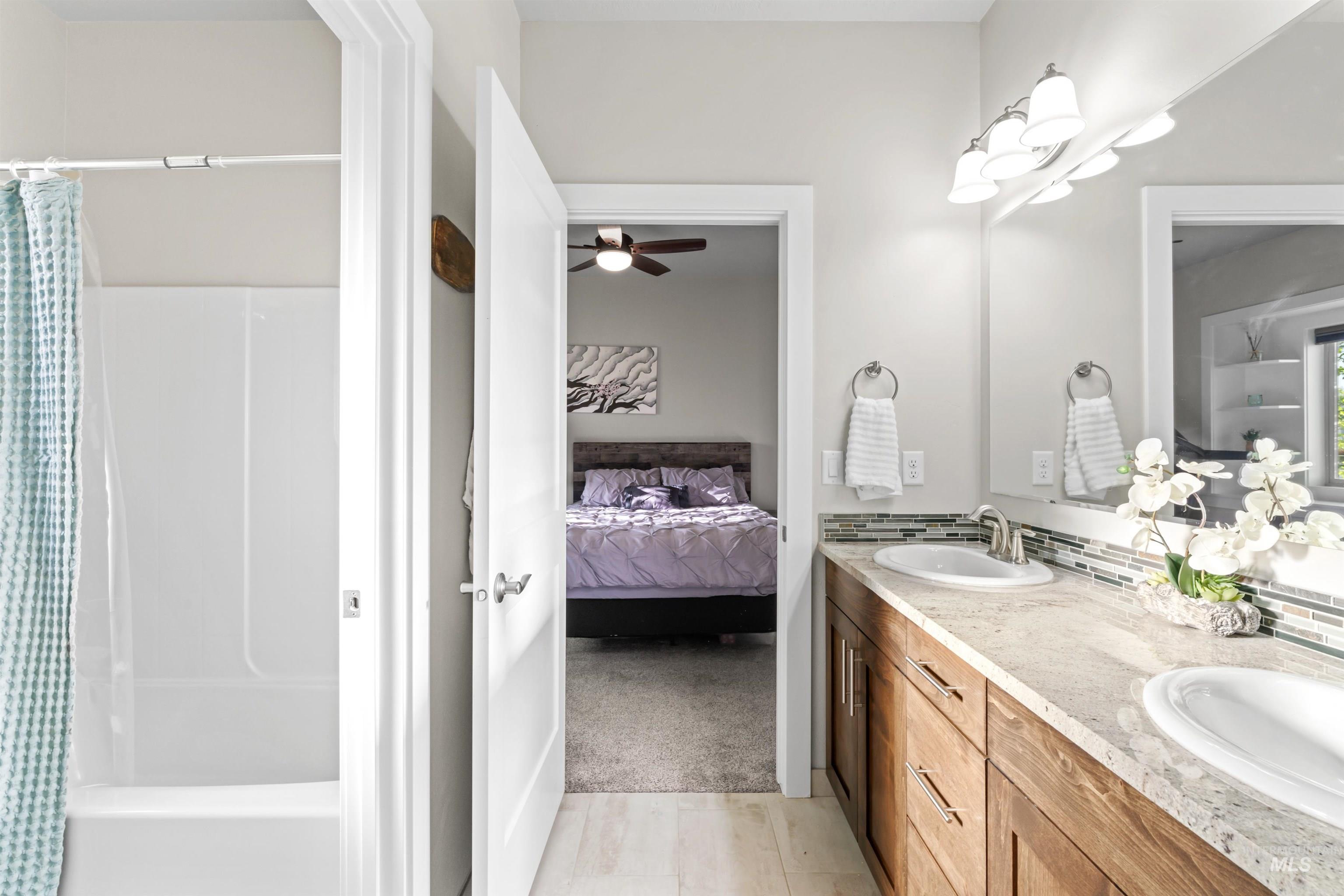 12356 West Rice Road Star, ID 83669 - Photo 30 of 49 Bathroom featuring double vanity, ensuite bathroom, ceiling fan, and light colored carpet