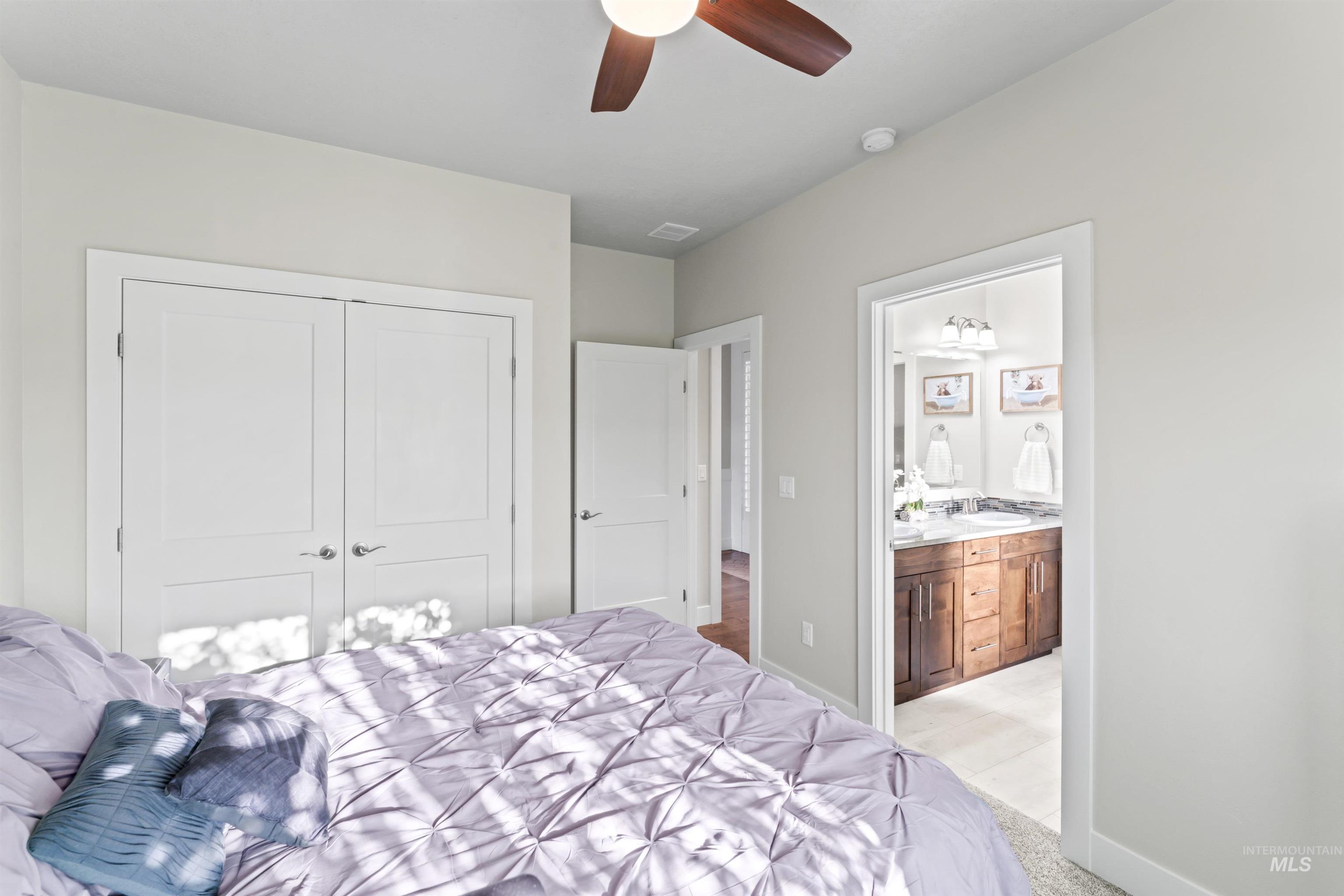 12356 West Rice Road Star, ID 83669 - Photo 34 of 49 Bedroom featuring light colored carpet, a ceiling fan, a closet, and connected bathroom