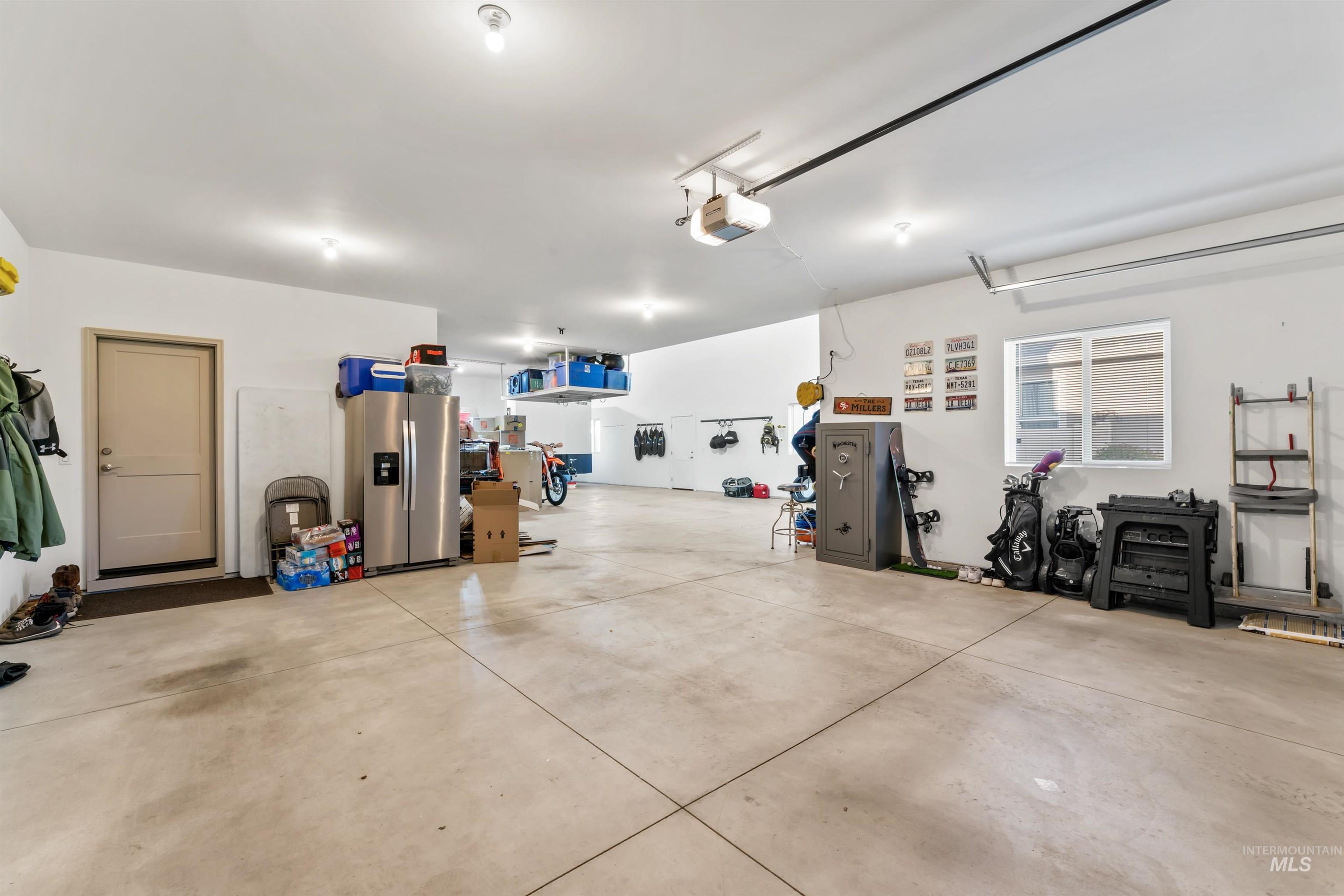12356 West Rice Road Star, ID 83669 - Photo 38 of 49 Garage with stainless steel fridge with ice dispenser and a garage door opener