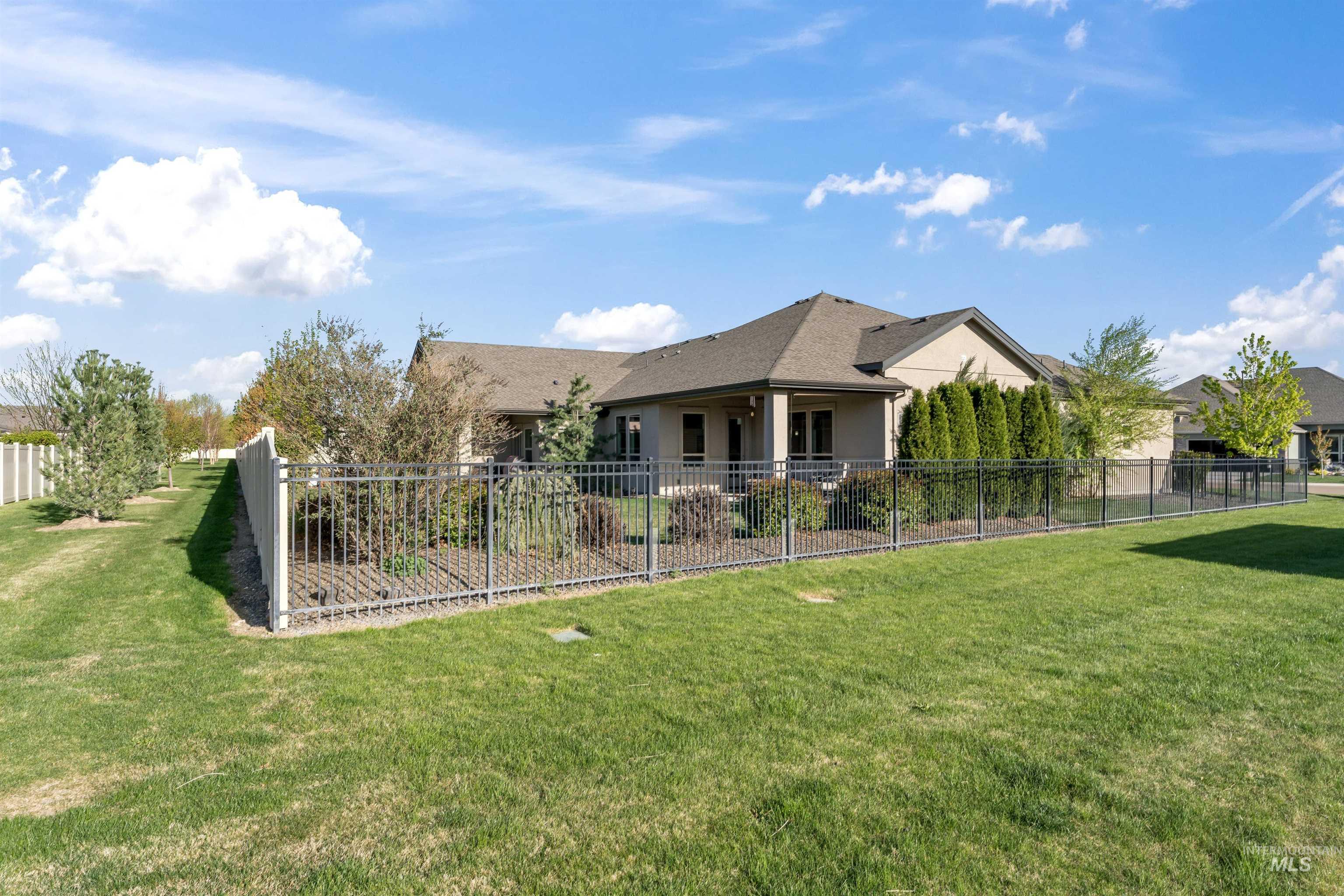 12356 West Rice Road Star, ID 83669 - Photo 45 of 49 Rear view of property with a fenced backyard, stucco siding, and a shingled roof