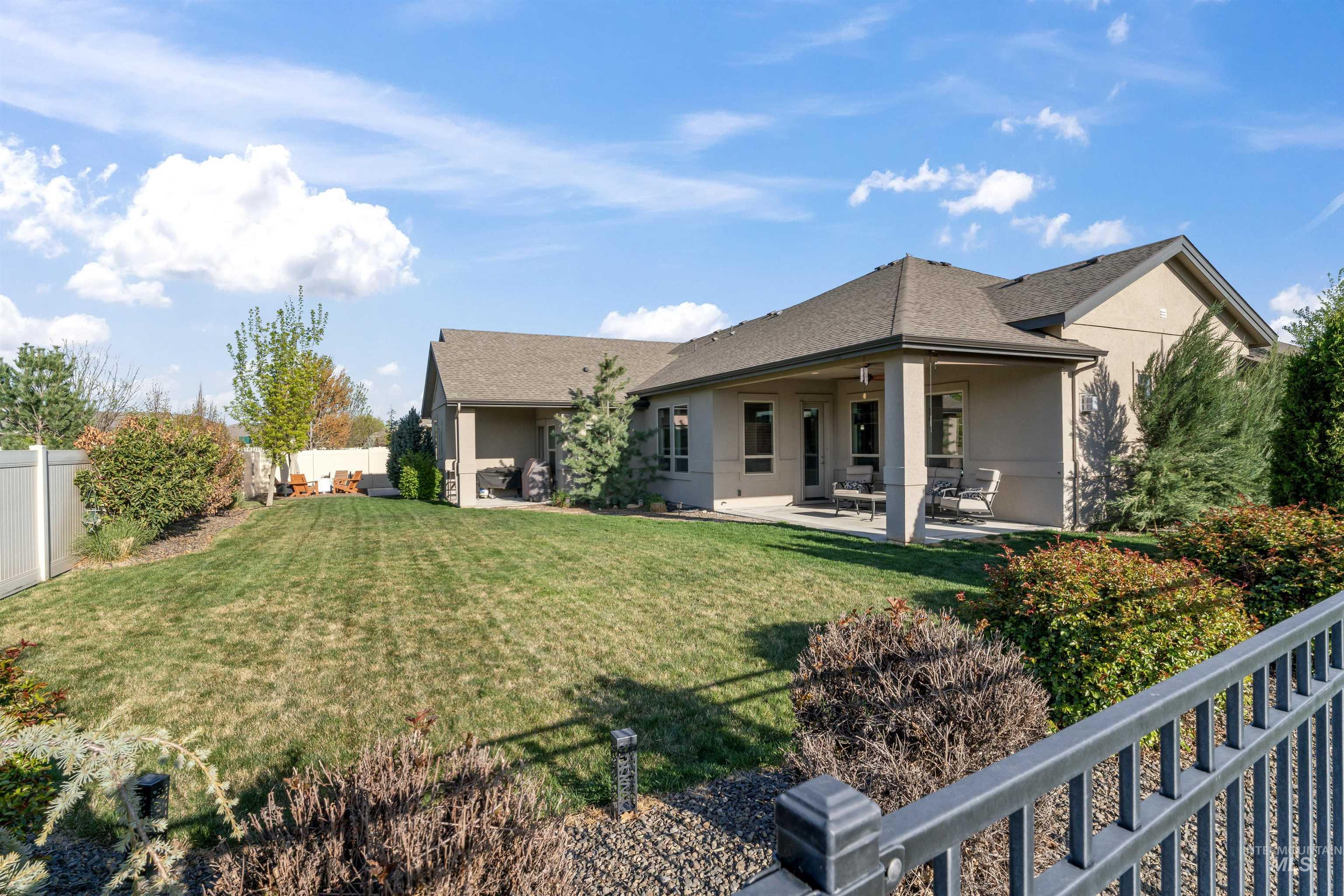 12356 West Rice Road Star, ID 83669 - Photo 46 of 49 Back of property with a fenced backyard, stucco siding, a patio area, and a shingled roof