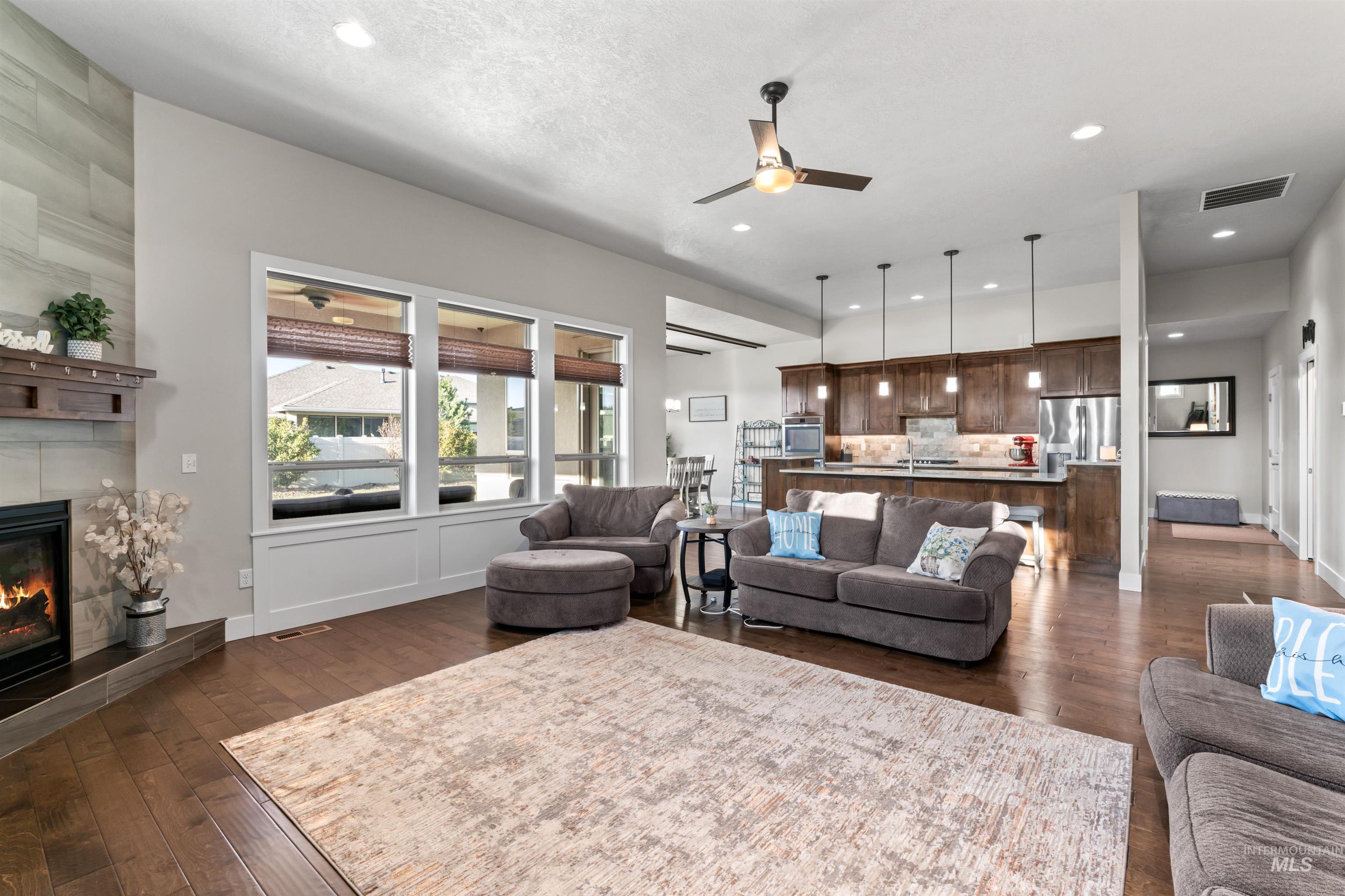 12356 West Rice Road Star, ID 83669 - Photo 6 of 49 Living room with dark wood-type flooring, a ceiling fan, a fireplace, and recessed lighting