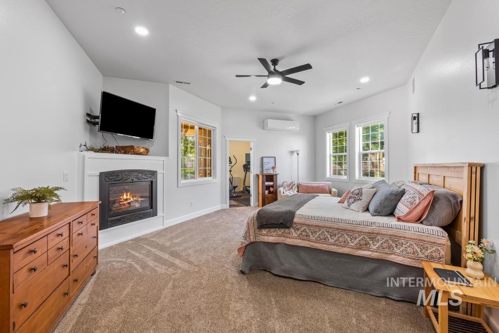 28279 Pearl Road Parma, ID 83660 - Photo 13 of 46 Bedroom featuring a glass covered fireplace, carpet, a ceiling fan, and recessed lighting