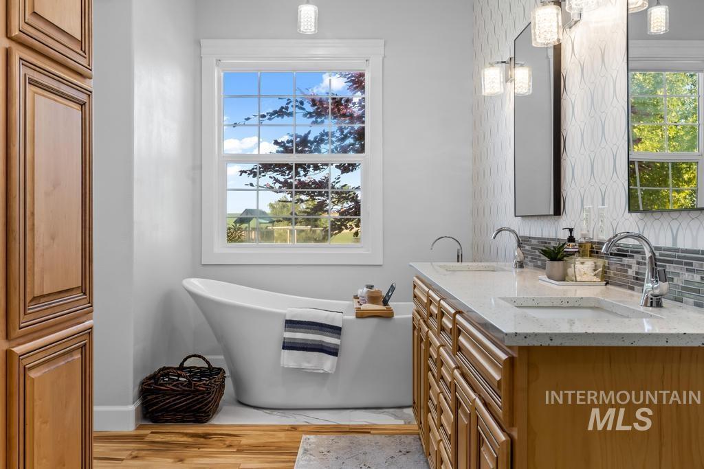 28279 Pearl Road Parma, ID 83660 - Photo 17 of 46 Full bathroom with a soaking tub, tasteful backsplash, double vanity, and plenty of natural light