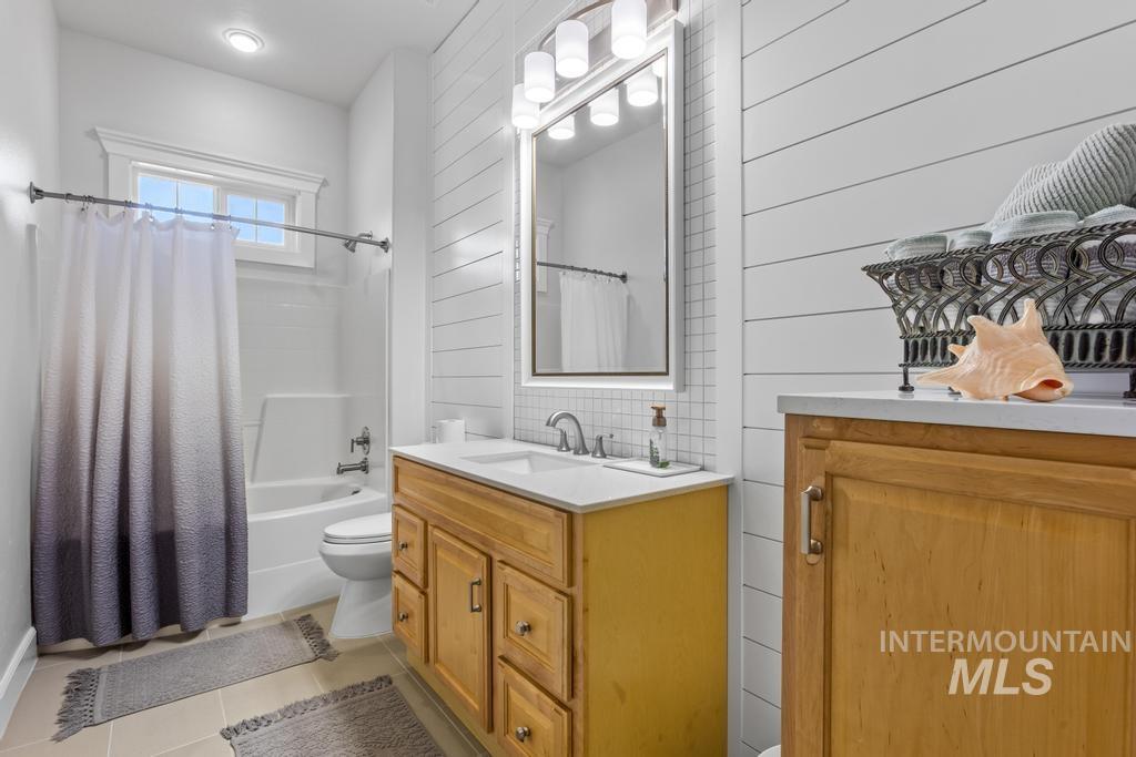 28279 Pearl Road Parma, ID 83660 - Photo 33 of 46 Bathroom featuring shower / bath combo with shower curtain, vanity, and light tile patterned flooring