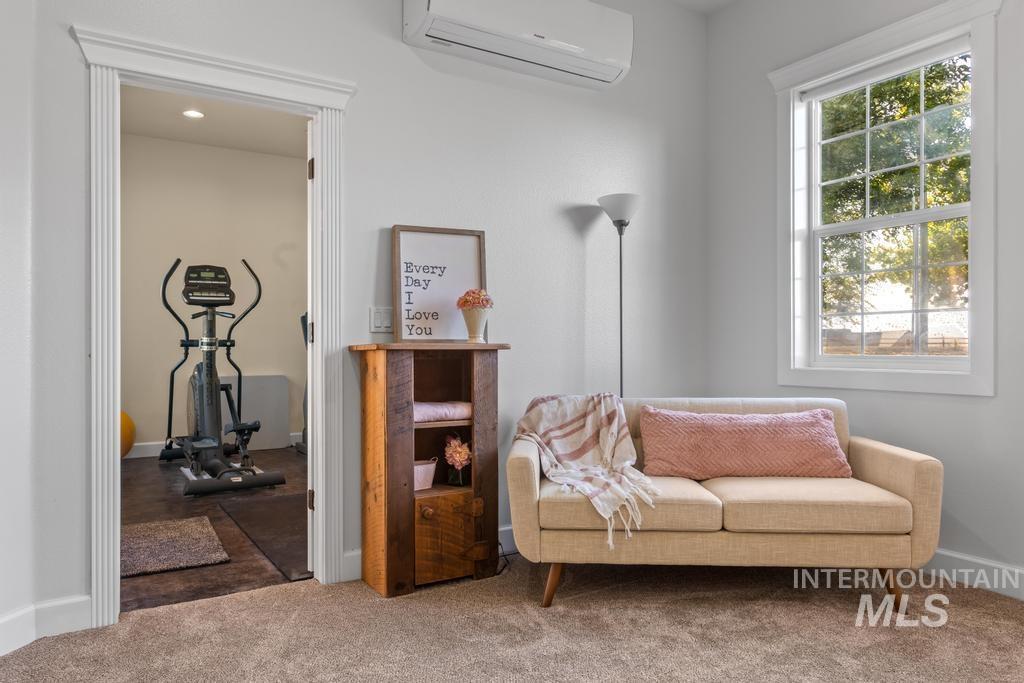 28279 Pearl Road Parma, ID 83660 - Photo 39 of 46 Living area with a wall mounted air conditioner and carpet flooring