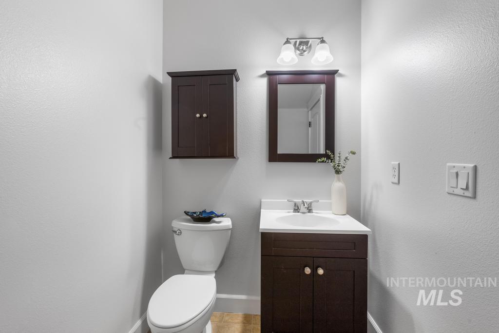 28279 Pearl Road Parma, ID 83660 - Photo 44 of 46 Half bath featuring vanity, a textured wall, and light tile patterned floors