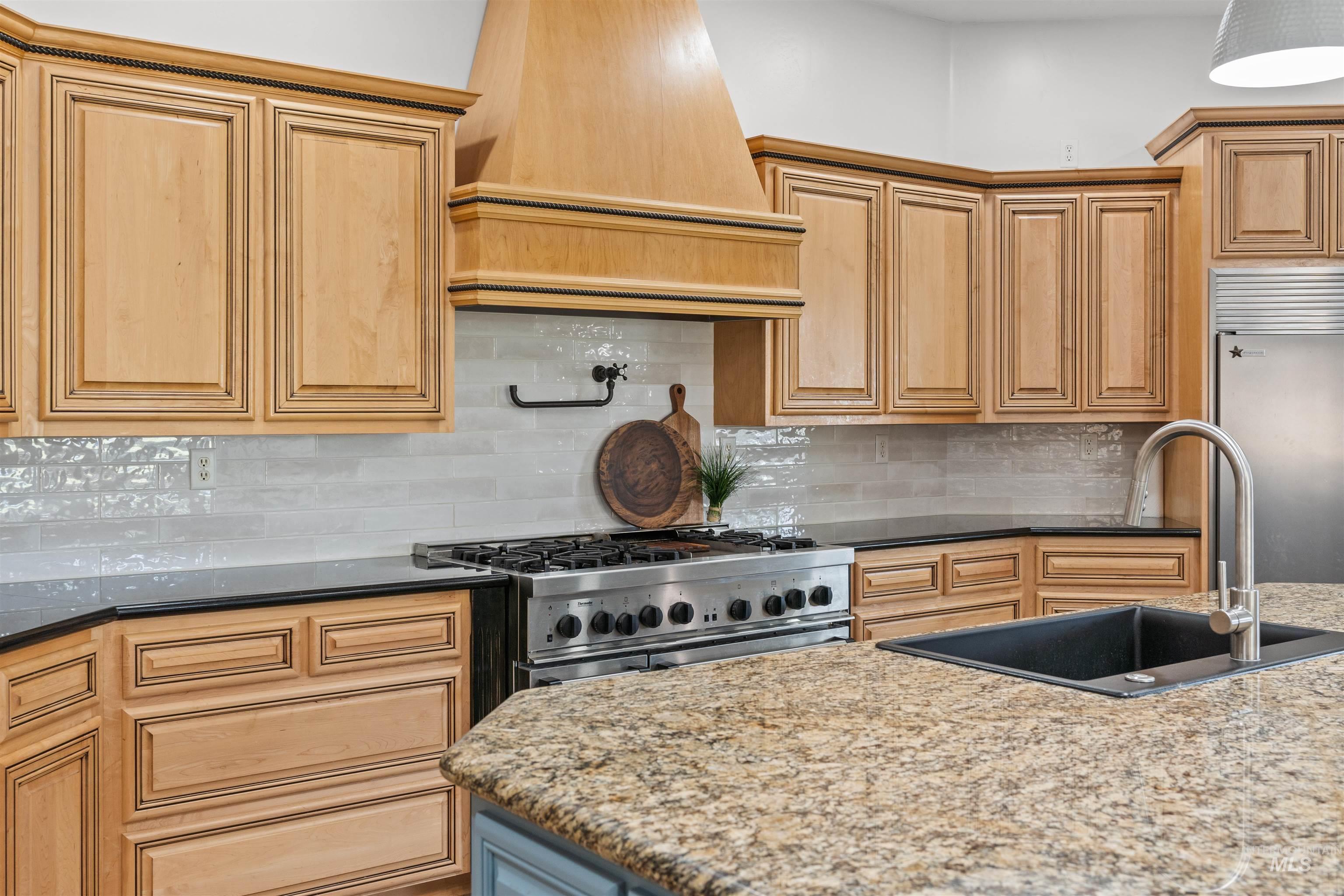 28279 Pearl Road Parma, ID 83660 - Photo 9 of 46 Kitchen featuring tasteful backsplash, dark stone counters, custom range hood, and light brown cabinetry