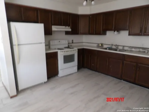 a kitchen with a refrigerator sink and cabinets