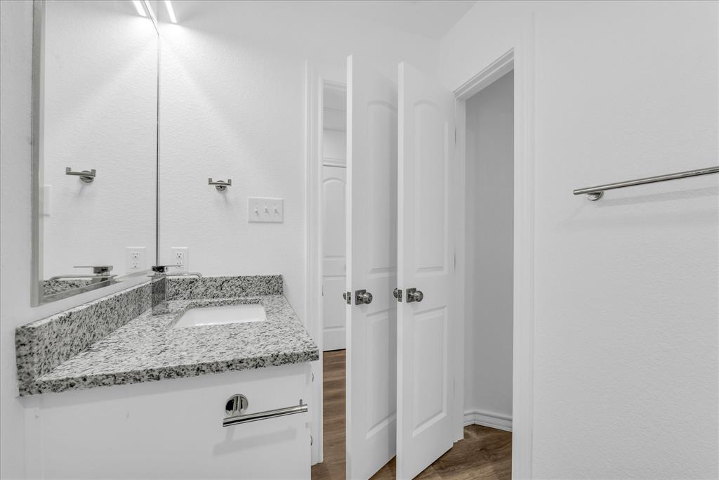 204 North Wiebusch Street Riesel, TX 76682 - Photo 23 of 33 a bathroom with a granite countertop sink and a mirror