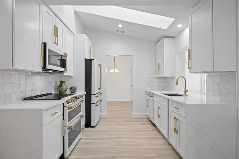 a kitchen with stainless steel appliances granite countertop a stove and a sink