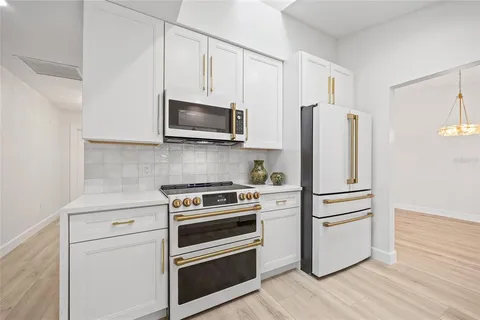 a kitchen with a refrigerator stove and white cabinets