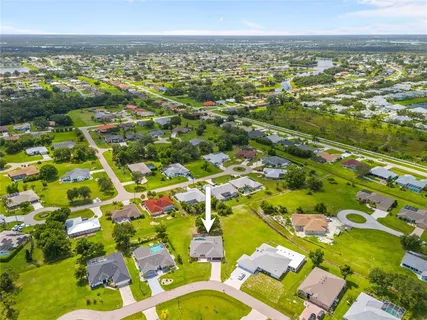 an aerial view of a house with swimming pool and outdoor seating