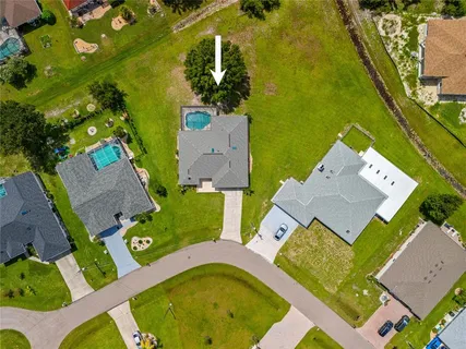 a aerial view of a house with a big yard and large trees