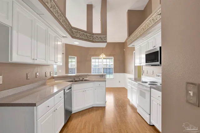 a kitchen with granite countertop a sink stainless steel appliances a counter top space and cabinets