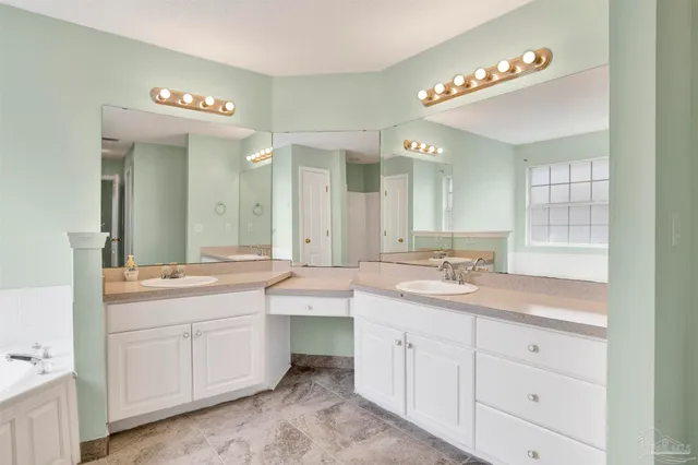 a spacious bathroom with a granite countertop sink mirror and